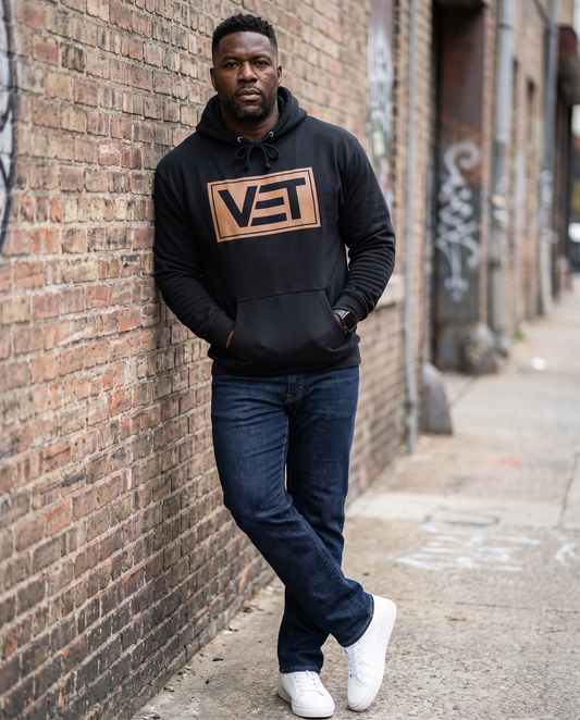 Man wearing black VET pullover hoodie, urban setting